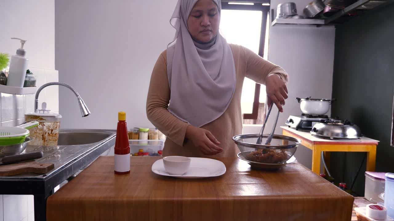 一名女子用白色盘子盛着酥脆的炸鸡，配上番茄酱或辣椒酱视频素材