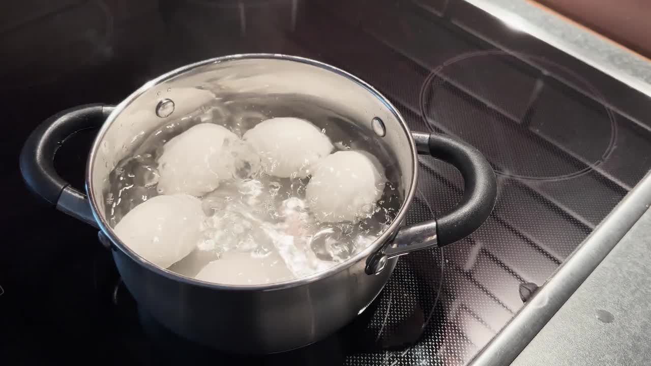 鸡蛋在沸水中煮。农场新鲜的有机煮鸡蛋。鸡蛋在小火锅里煮视频下载