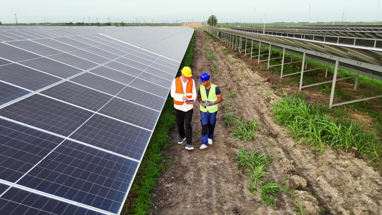 工程师和他的技术员正在检查太阳能电池板的效率视频素材