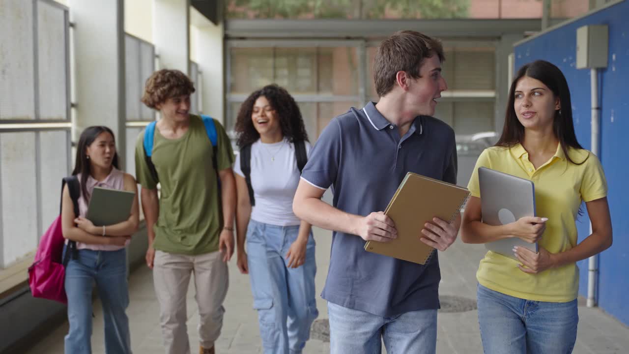 一群兴高采烈的中学生返校上课。十几岁的朋友步行到高中学院。教育多样性视频下载