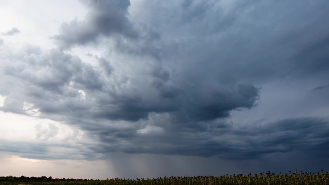 麦田上空的风暴云在时间流逝中移动。阴天夏雨景观。运动云和全球变暖概念。雷暴天气下的自然环境。戏剧性的天空视频素材