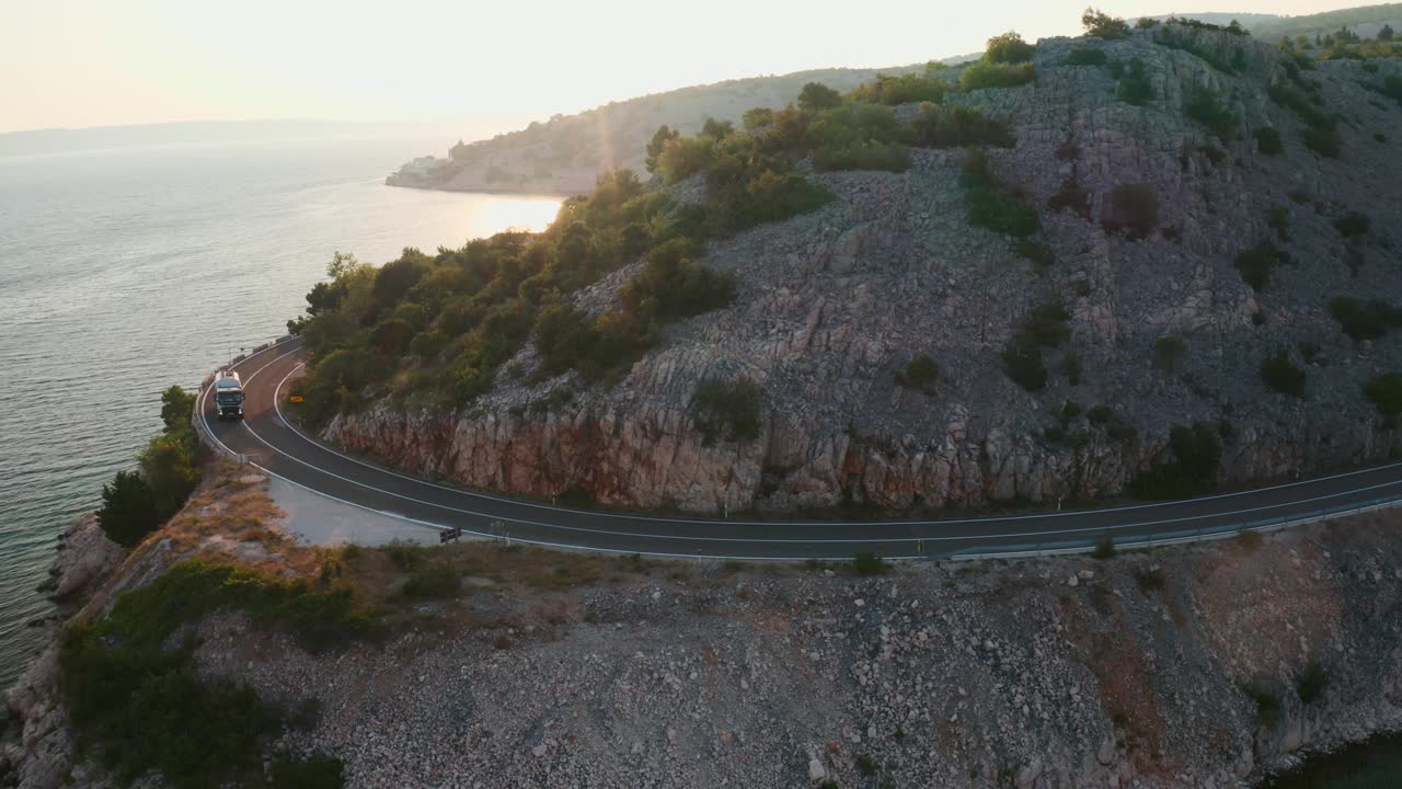 日落时分，卡车沿着蜿蜒的山路行驶视频素材