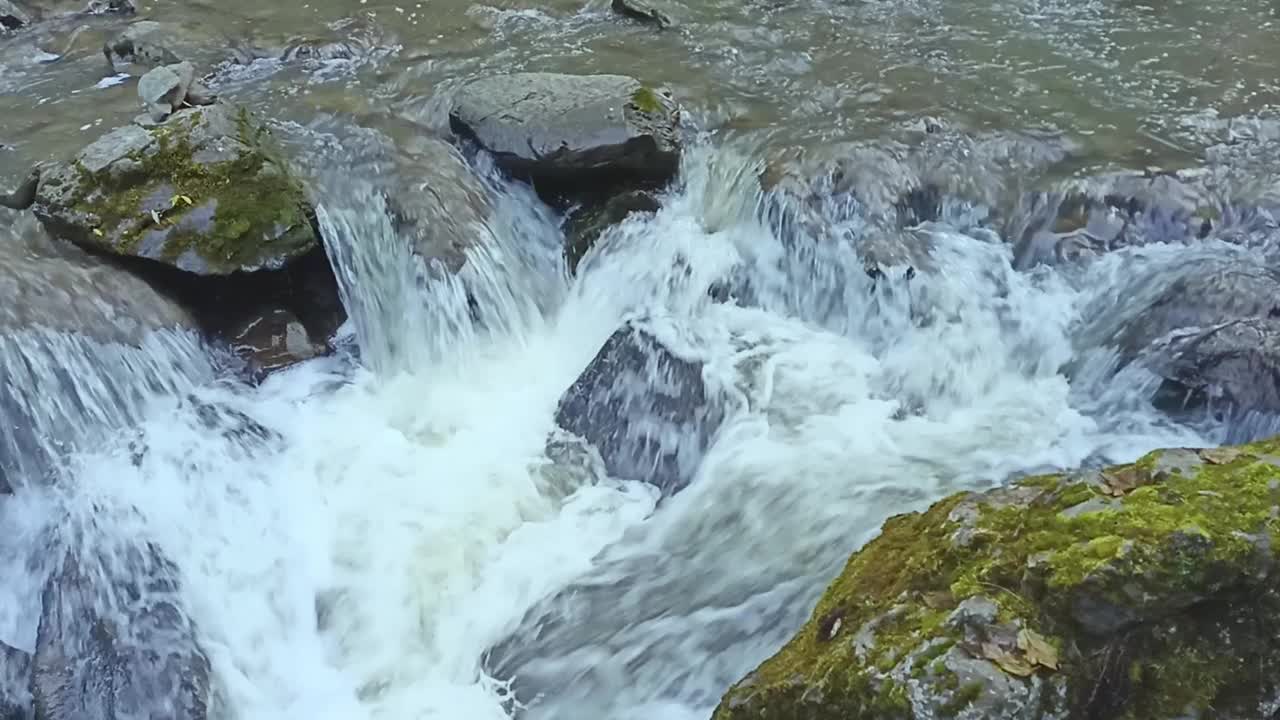 山石:在多云的秋日，山间河流的瀑布开始时从水面突出的大石头视频下载