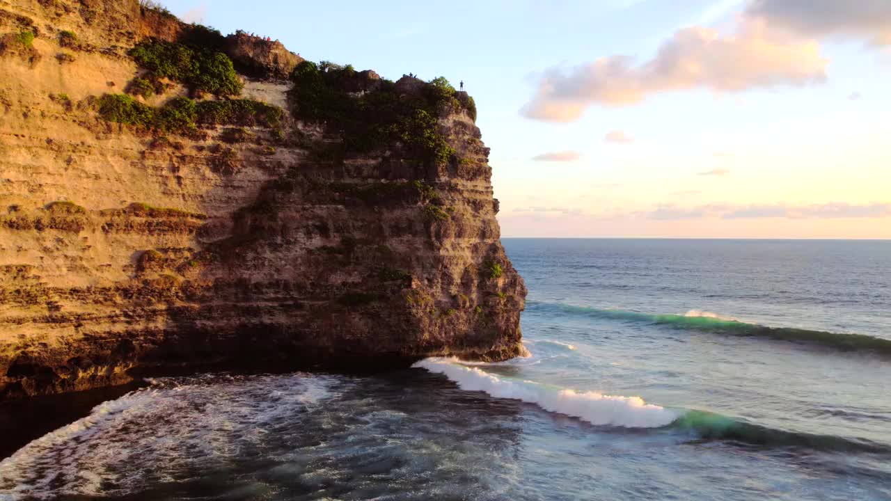 岩石悬崖海岸线和海洋，海，附近的乌鲁瓦图寺庙在巴厘岛，印度尼西亚视频下载