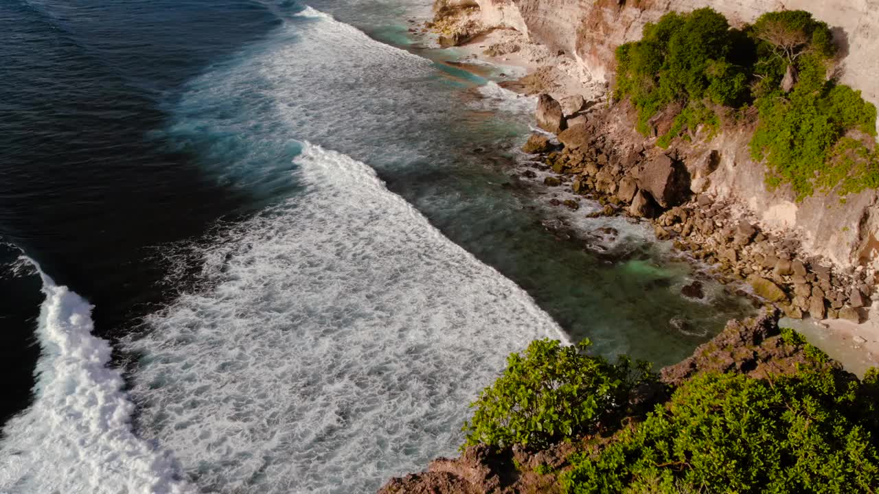 岩石悬崖海岸线和海洋，海，附近的乌鲁瓦图寺庙在巴厘岛，印度尼西亚视频素材