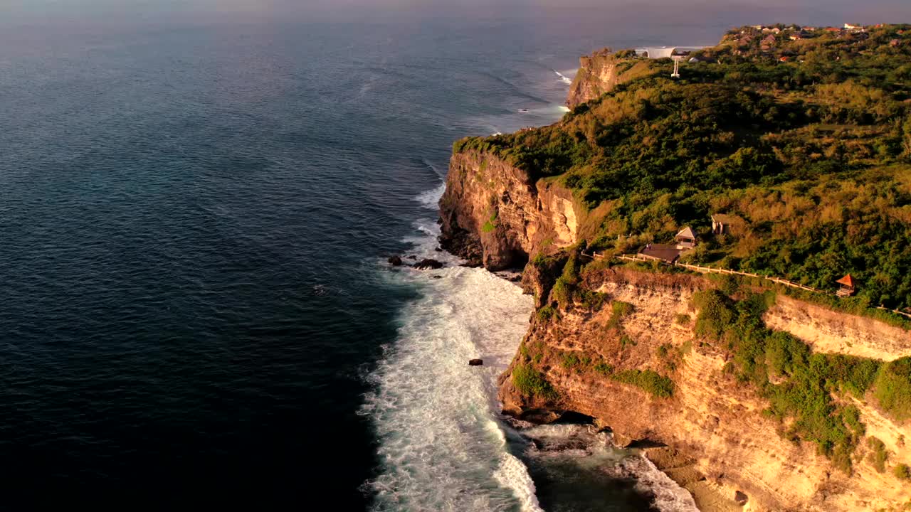 岩石悬崖海岸线和海洋，海，附近的乌鲁瓦图寺庙在巴厘岛，印度尼西亚视频下载