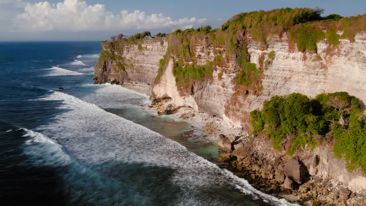 岩石悬崖海岸线和海洋，海，附近的乌鲁瓦图寺庙在巴厘岛，印度尼西亚视频下载