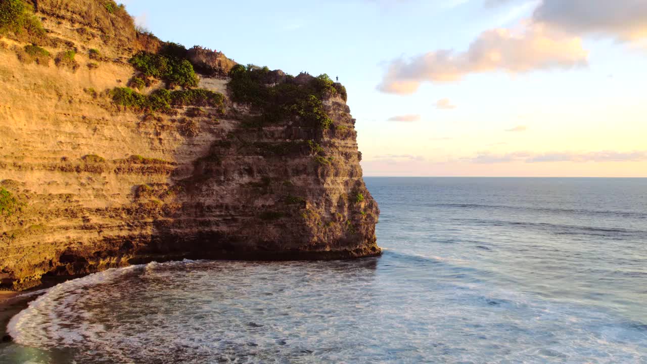 岩石悬崖海岸线和海洋，海，附近的乌鲁瓦图寺庙在巴厘岛，印度尼西亚视频下载