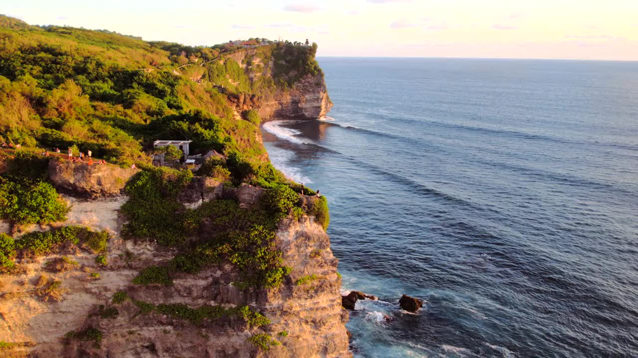 岩石悬崖海岸线和海洋，海，附近的乌鲁瓦图寺庙在巴厘岛，印度尼西亚视频素材