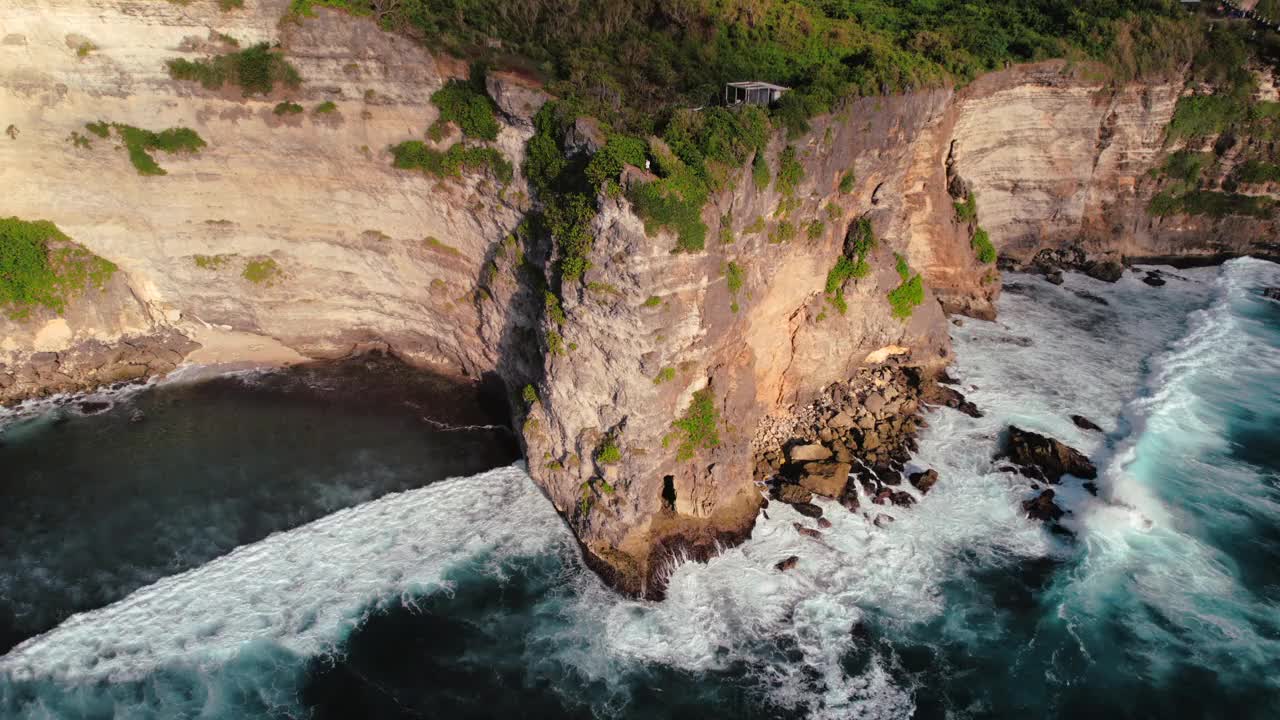 岩石悬崖海岸线和海洋，海，附近的乌鲁瓦图寺庙在巴厘岛，印度尼西亚视频下载