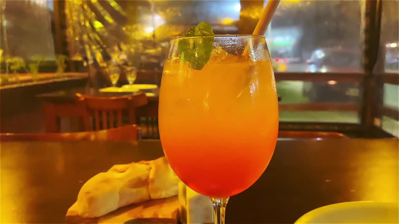 在咖啡馆的业余视频中，桌子上的Aperol Spitz鸡尾酒视频下载