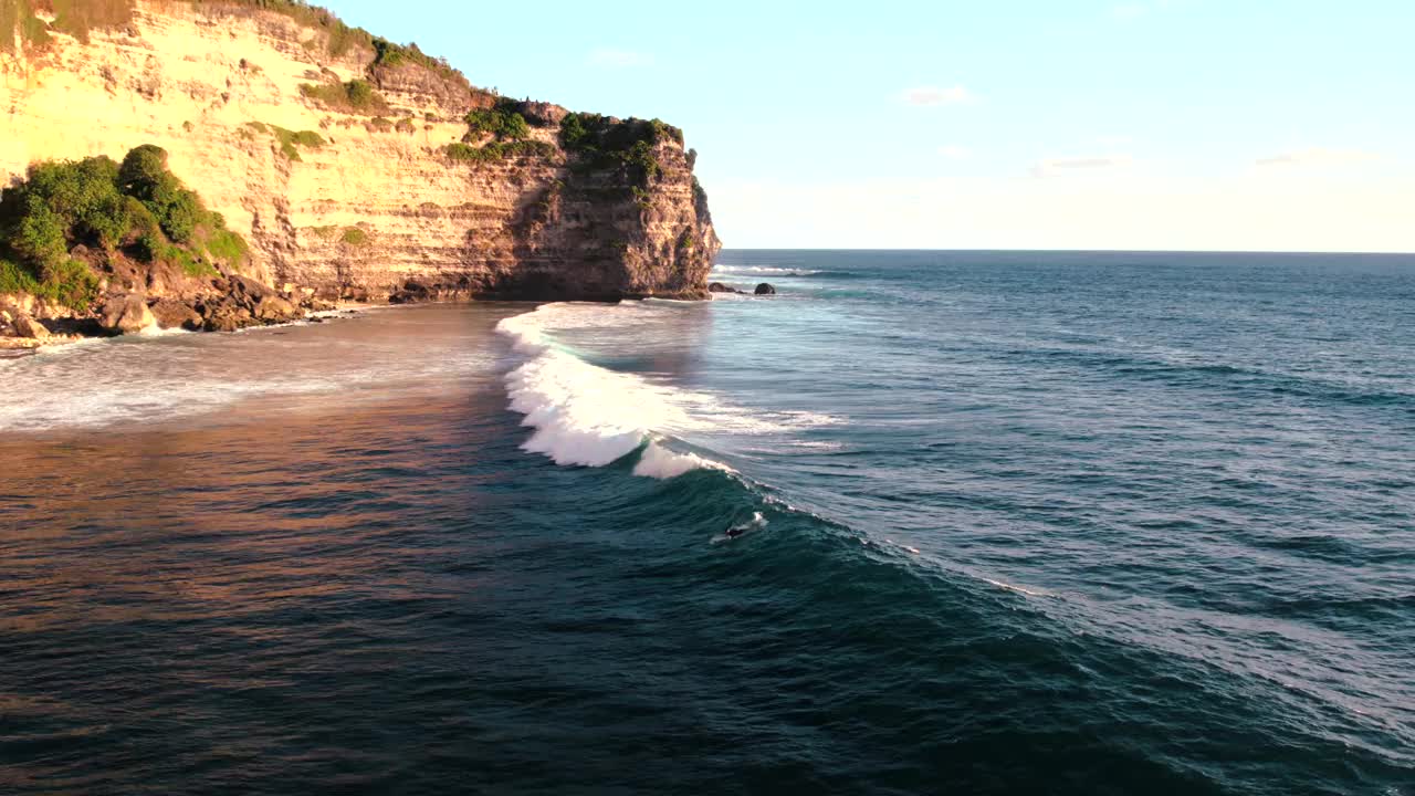 冲浪者在印度尼西亚巴厘岛乌鲁瓦图附近的海洋中乘风破浪视频素材