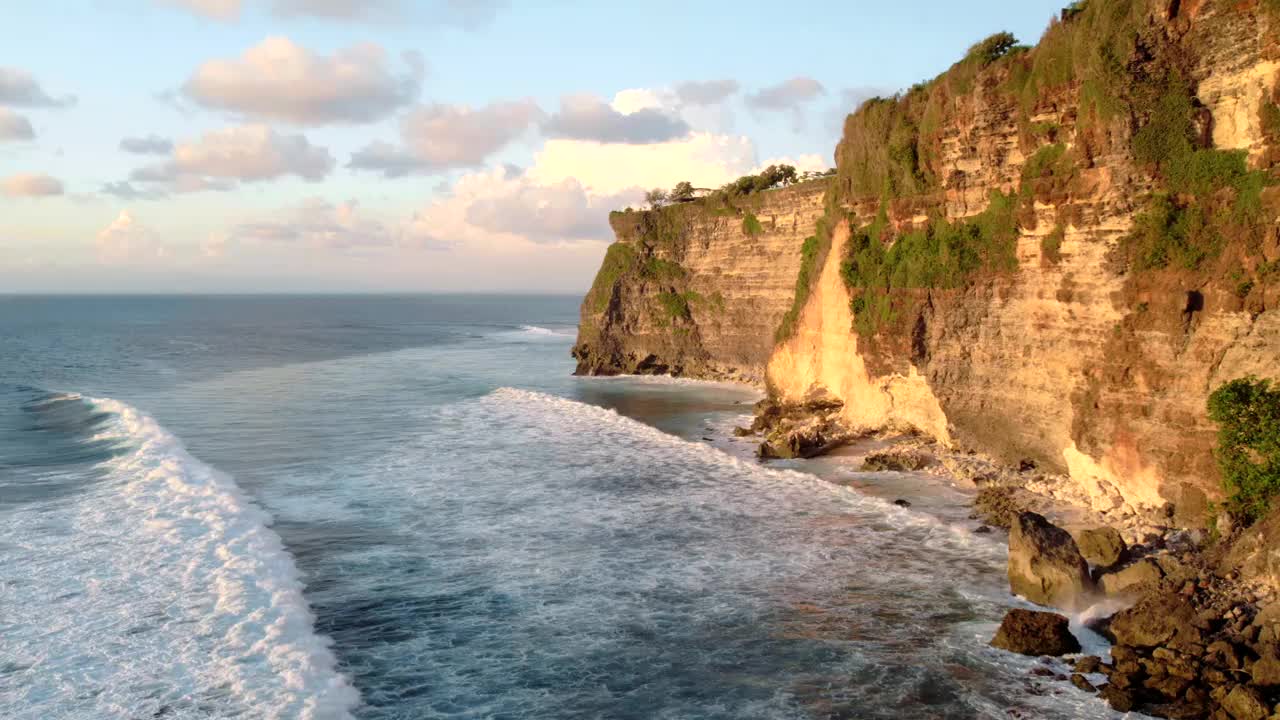 岩石悬崖海岸线和海洋，海，附近的乌鲁瓦图寺庙在巴厘岛，印度尼西亚视频下载