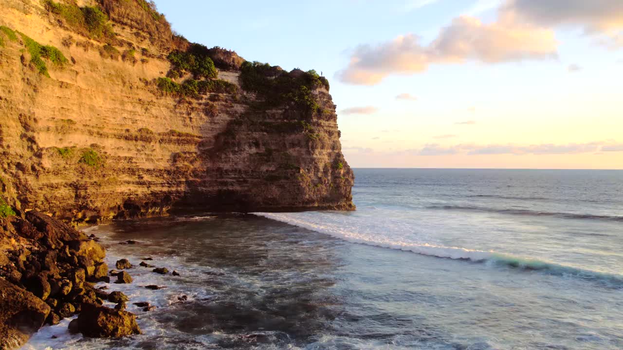 岩石悬崖海岸线和海洋，海，附近的乌鲁瓦图寺庙在巴厘岛，印度尼西亚视频素材