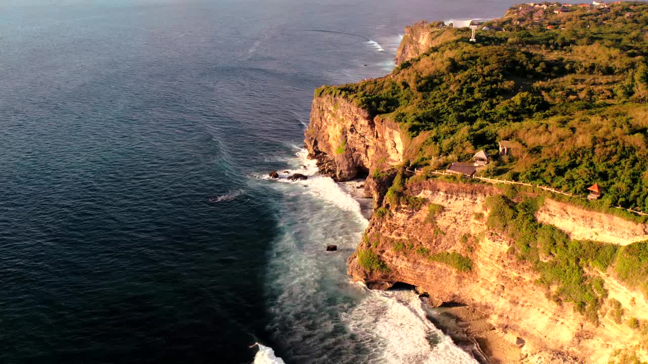 岩石悬崖海岸线和海洋，海，附近的乌鲁瓦图寺庙在巴厘岛，印度尼西亚视频素材