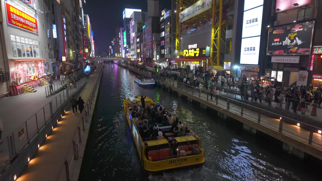 日本大阪，道顿堀运河上的观光船，两边都有发光的招牌视频下载