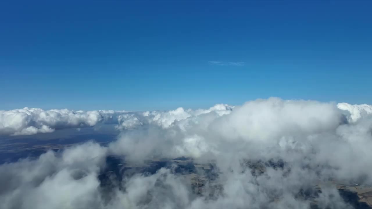 身临其境的飞行员POV飞行通过一些蓬松的白云在灿烂的蓝天。4 k 60 fps视频素材