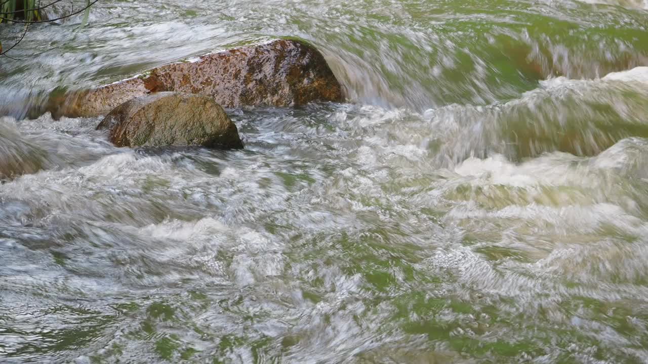 在山涧中，水在光滑的岩石上倾泻而下视频素材