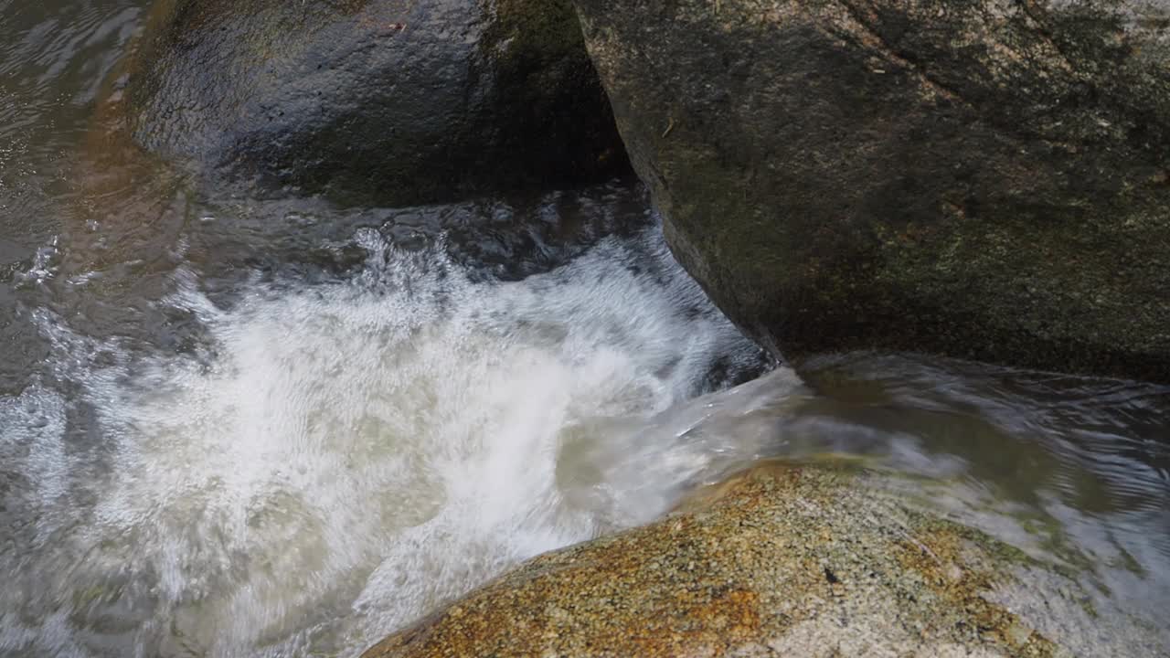 在山涧中，水在光滑的岩石上倾泻而下视频下载