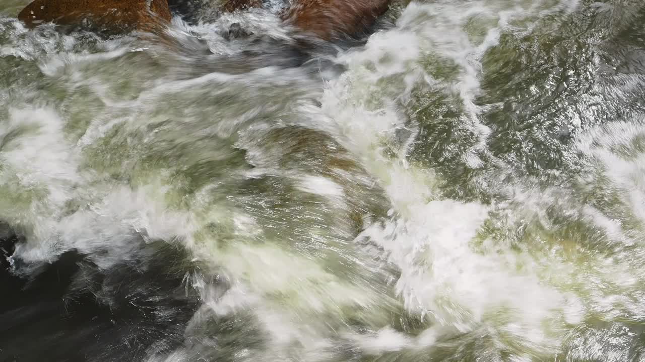 在山涧中，水在光滑的岩石上倾泻而下视频素材