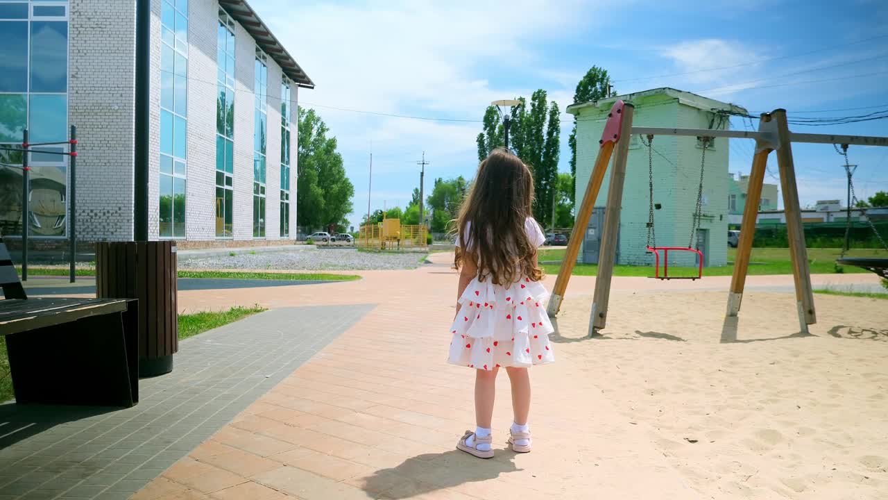 小女孩在操场上荡秋千，哭得很伤心。孩子们在户外玩耍，孩子们在户外，暑假和假期视频素材