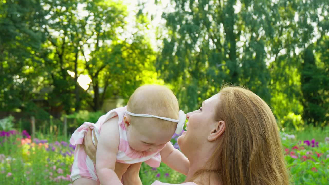 妈妈在公园里又抛又接。妈妈和孩子在大自然中玩耍视频素材