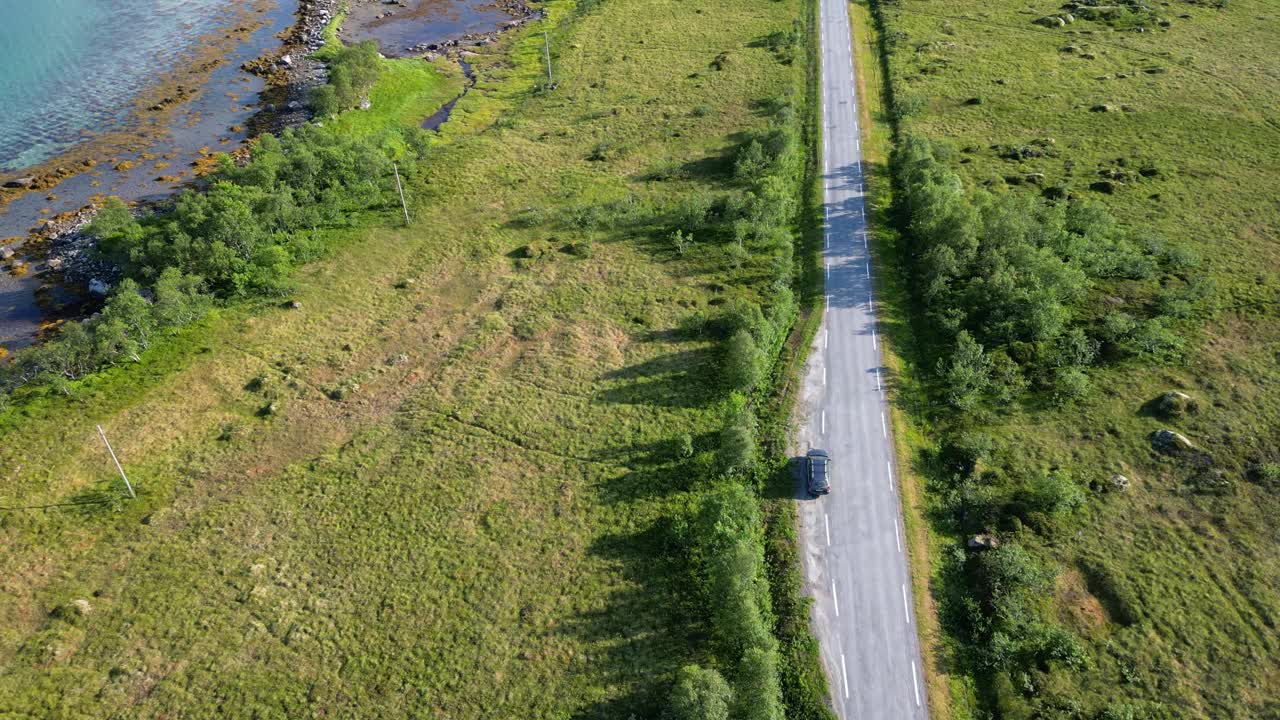 鸟瞰图的道路与汽车通过绿色田野在海上在安多亚，挪威视频下载