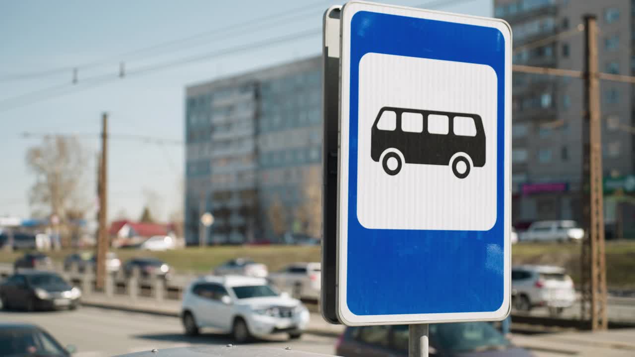 以繁忙道路为背景的城市巴士站标志近景视频素材