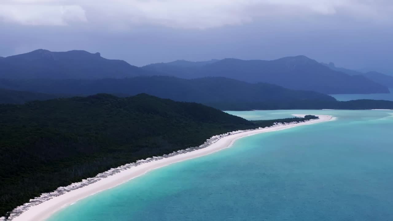 白天堂海滩圣灵岛空中无人机视差Airlie国家公园澳大利亚澳大利亚昆士兰多云多雨的蓝天外大堡礁清澈的蓝色绿松石海洋白色的沙子圆右视频素材