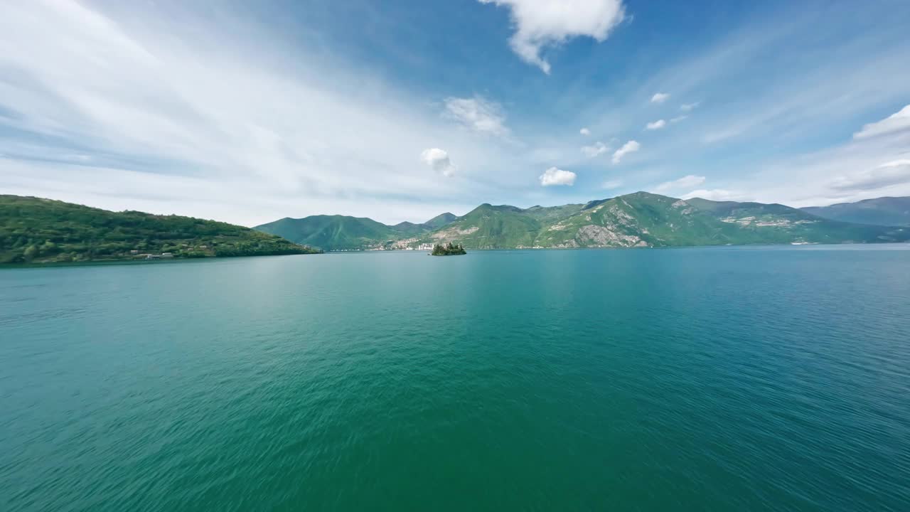 洛雷托岛在伊塞奥湖美丽的山脉背景和晴朗的天空，鸟瞰图视频素材