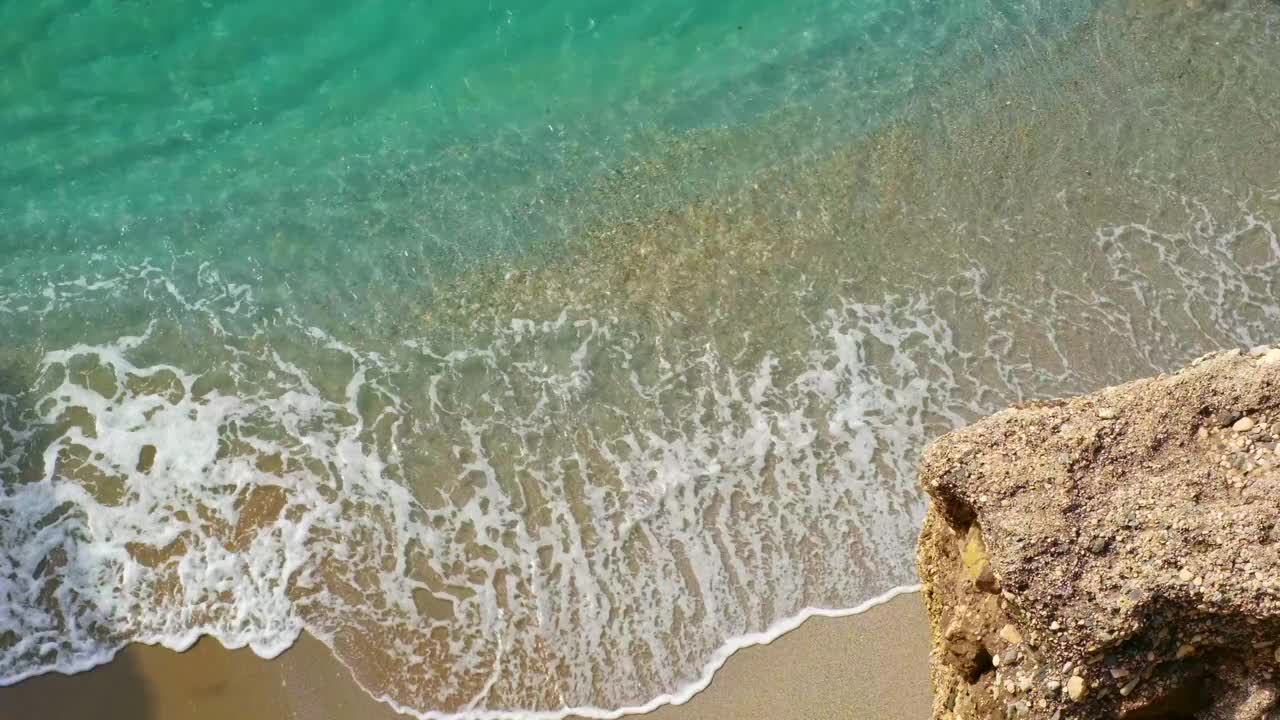 美丽的海滩，绿松石般的海水翻滚在岸边的海浪上视频下载