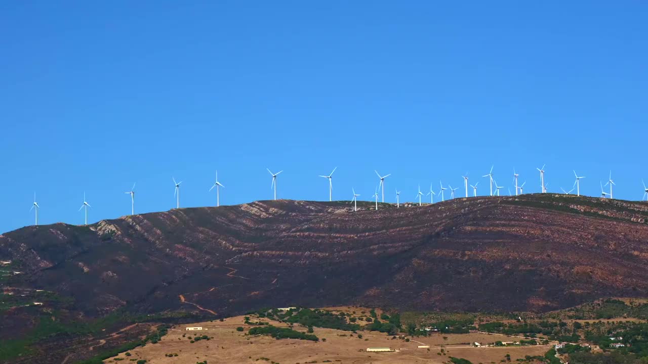 风力涡轮机建在一座高山上，叶片在风中旋转视频素材