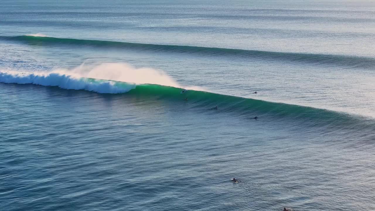 在理想的巨浪上冲浪。与冲浪者在巴厘岛的海洋完美的海浪。无人机的观点视频素材