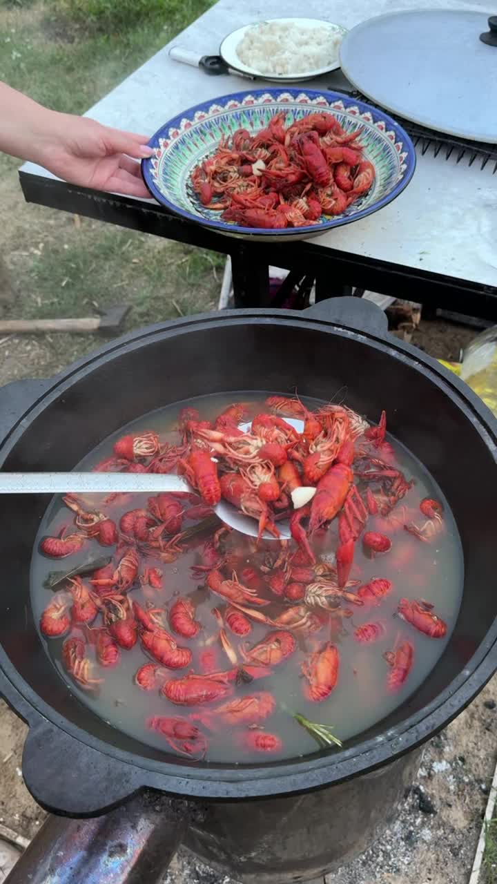 厨师用漏勺将河小龙虾从沸水中捞出。煮过的小龙虾已经变红了。垂直视频。视频素材