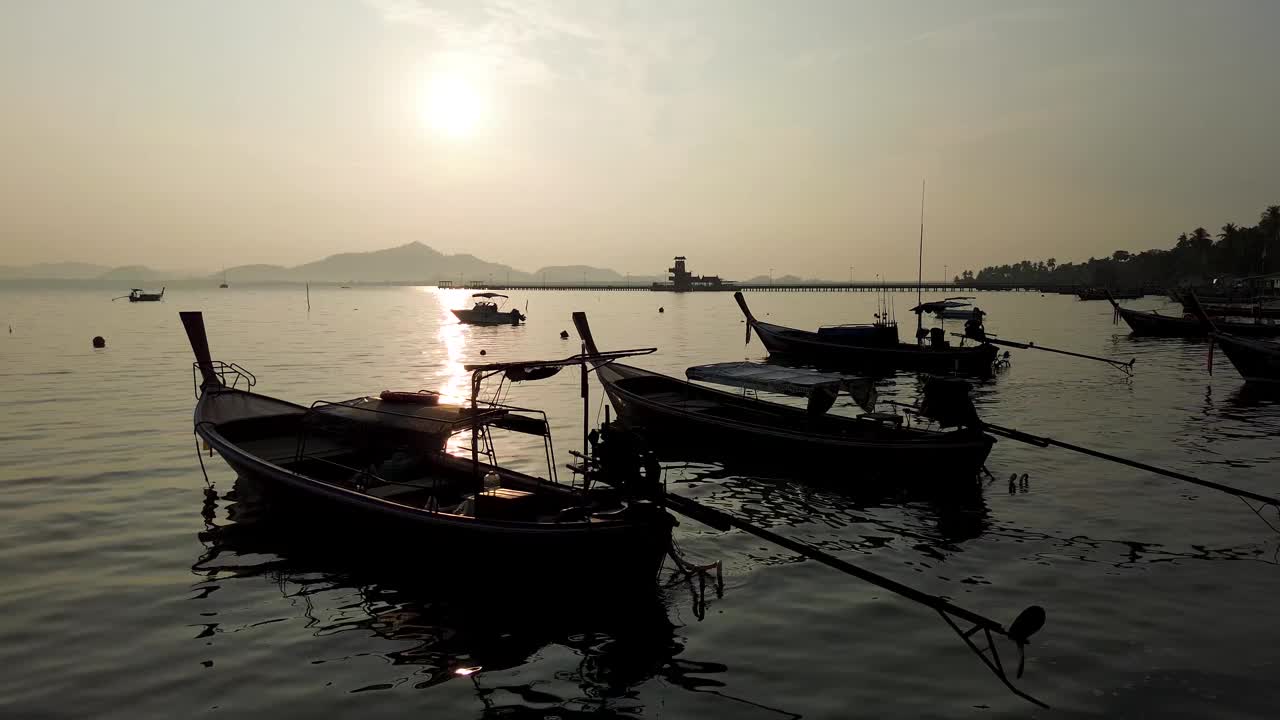 日出时，一艘渔船停泊在泰国董里岛的海滩上，壮观的天空视频下载