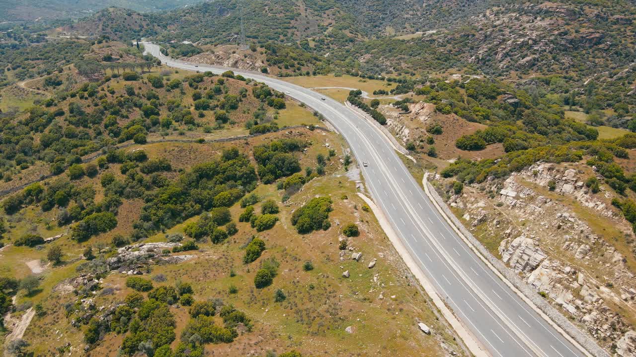 蜿蜒的公路穿过山间，汽车川流不息视频素材