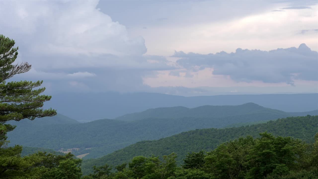 静态拍摄的全景，郁郁葱葱，绿色的山延伸到远处。云在天空中优雅地移动，在宁静的景观上创造出动态多变的场景。视频素材