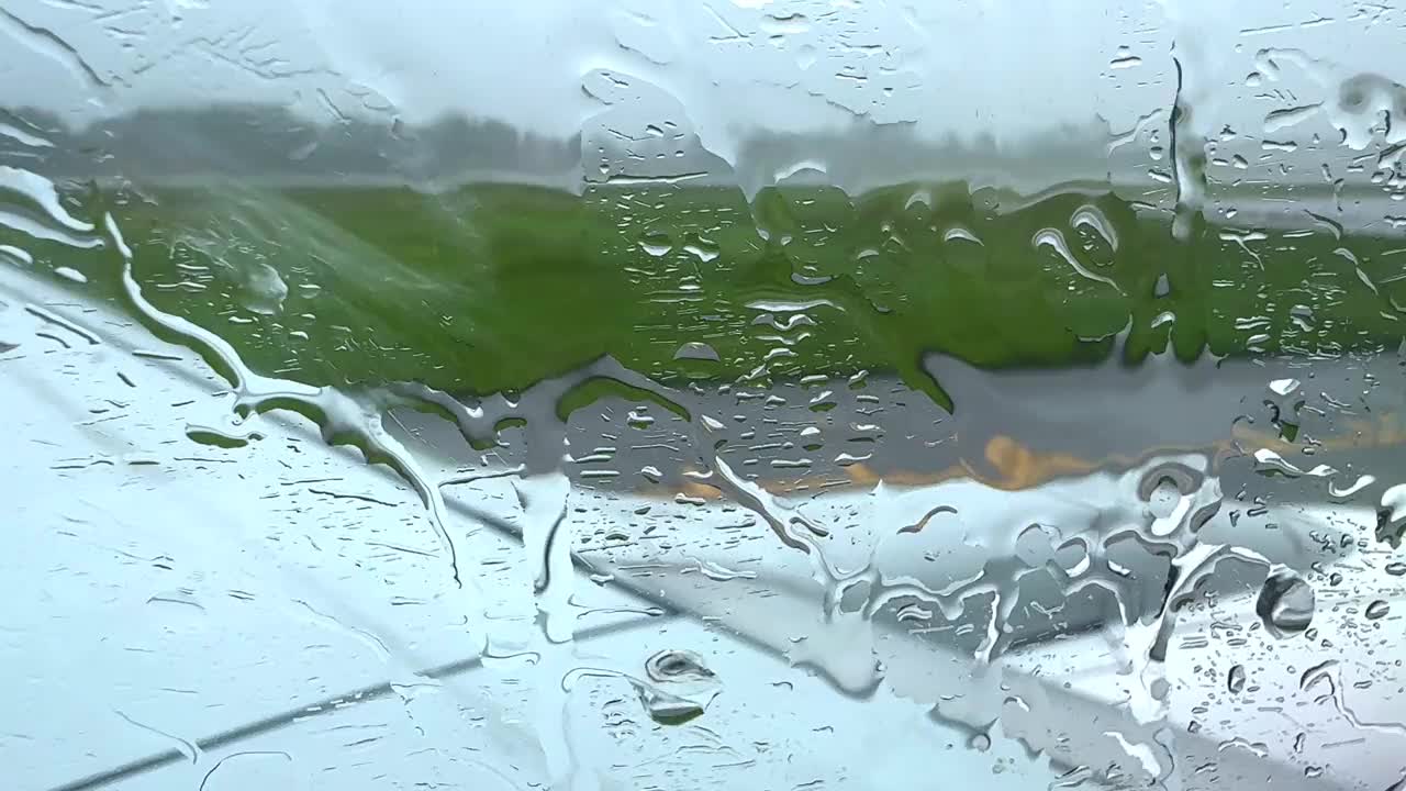 一个下雨天，一架飞机停在泰国普吉岛机场的停机坪上，雨滴顺着飞机的窗户流下来视频素材