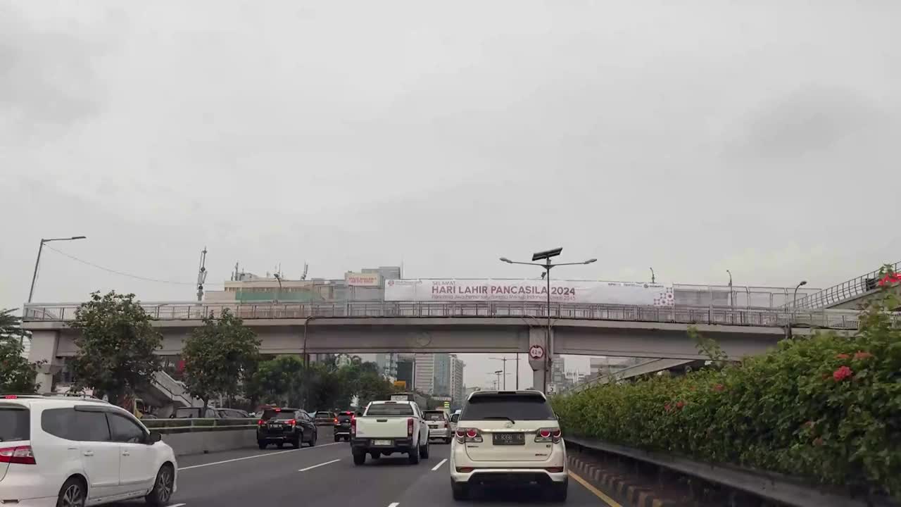 在一个阳光明媚的日子里，沿着印度尼西亚首都雅加达的主要道路大道，开车穿过现代化的雅加达商业区视频下载