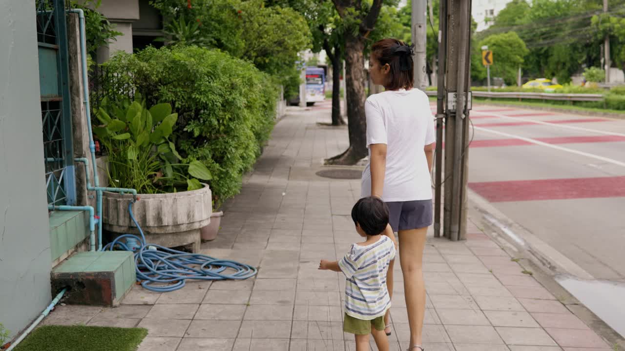 一位亚洲母亲带着儿子散步。视频下载