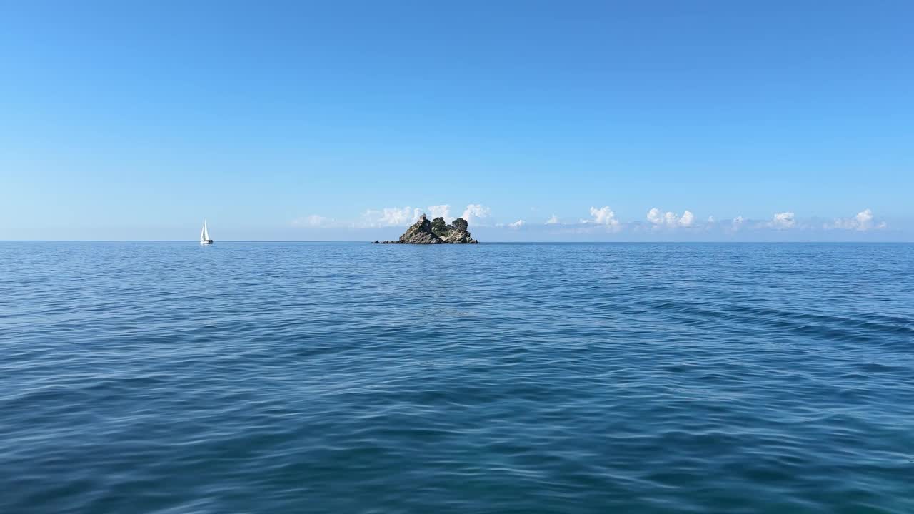 蓝色的大海，岩石，帆船。视频素材