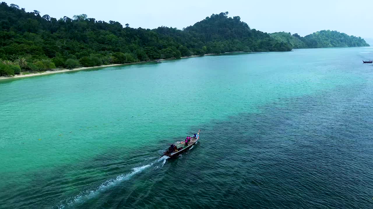 鸟瞰图的长尾船行驶通过海滩与清澈的海水礁。董里,泰国视频下载