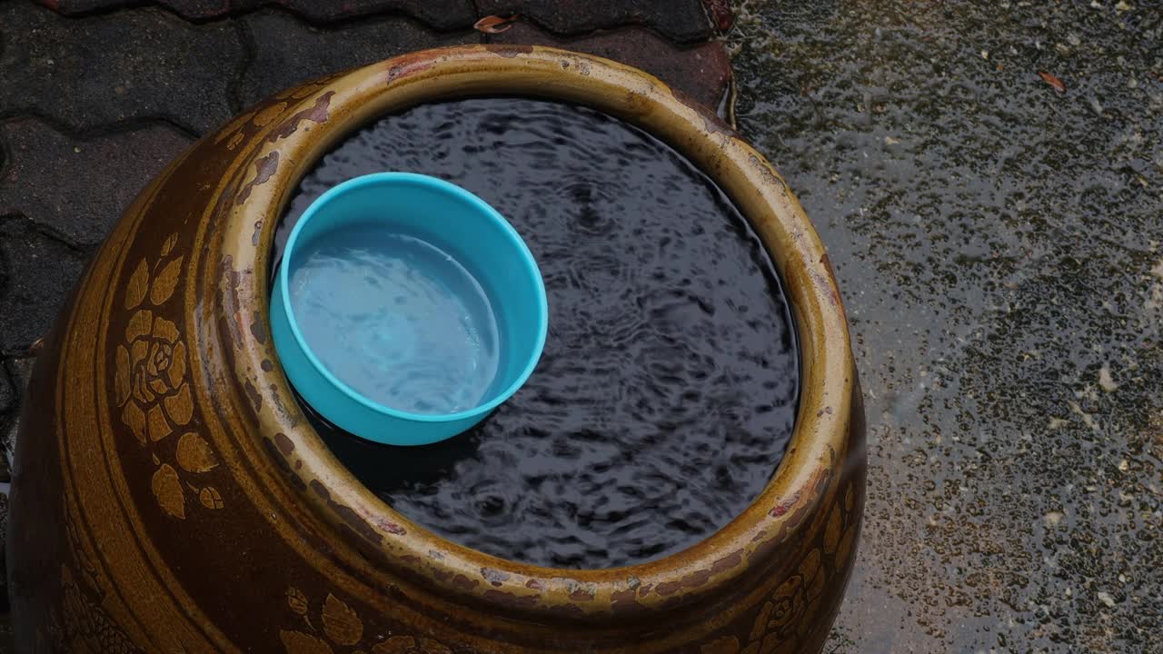 雨季里，雨滴落在旧陶罐里，溅起雨水。概念享受放松的自然。视频下载