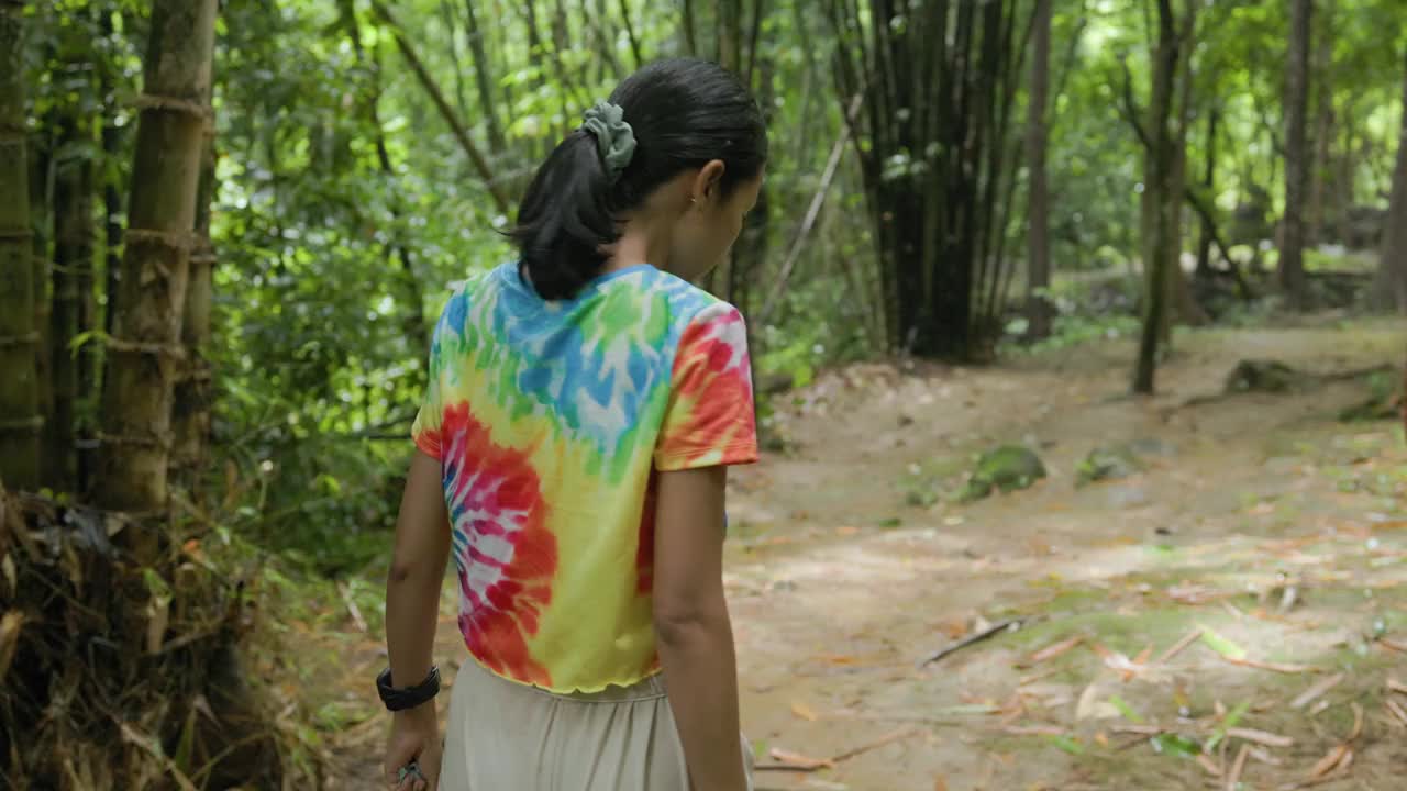 在瀑布雨林中散步的女人。视频下载