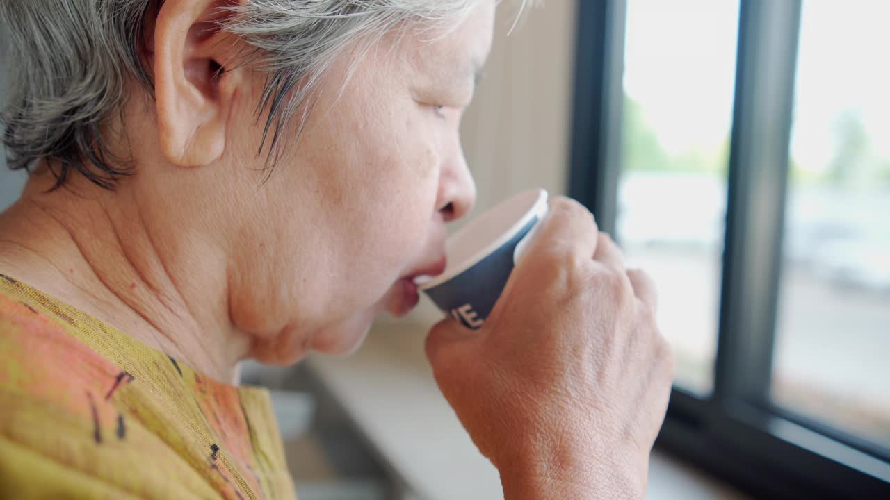 老年妇女喝咖啡的特写视频下载