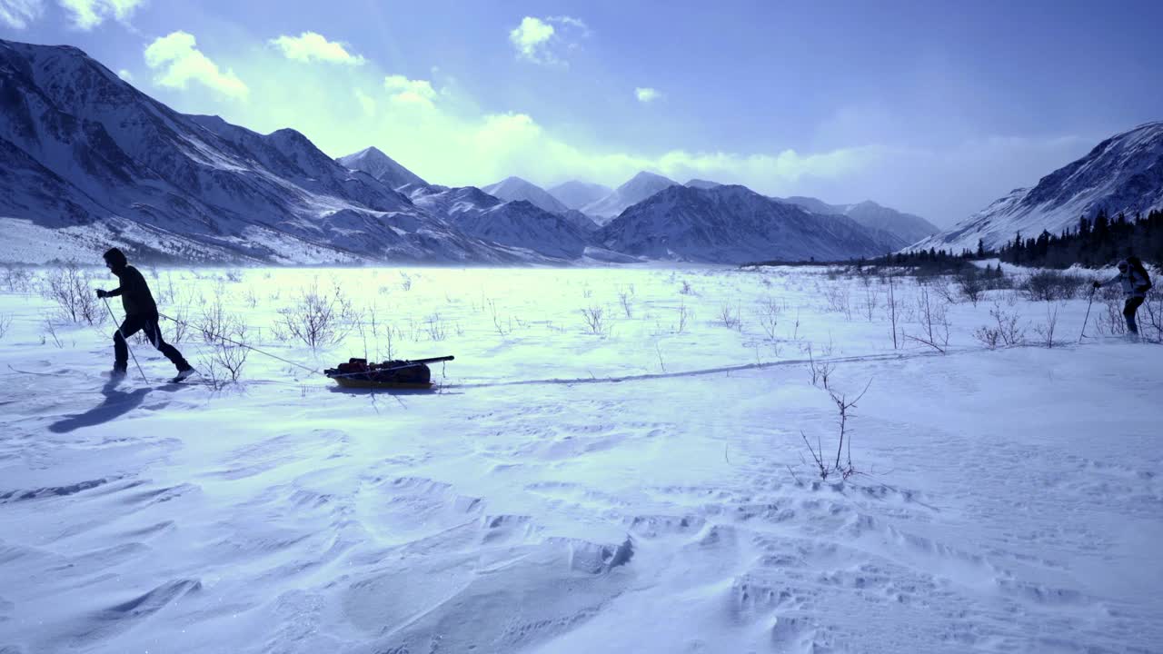 在阿拉斯加的德纳里国家公园，一个人带着设备在雪景上拉雪橇视频下载