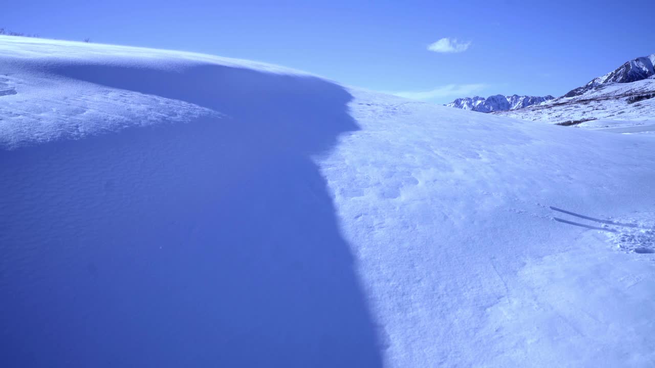 航拍:无人机拍摄的美丽的雪在斜坡上流动在宁静的国家公园在阳光明媚的日子-德纳里国家公园，阿拉斯加视频下载