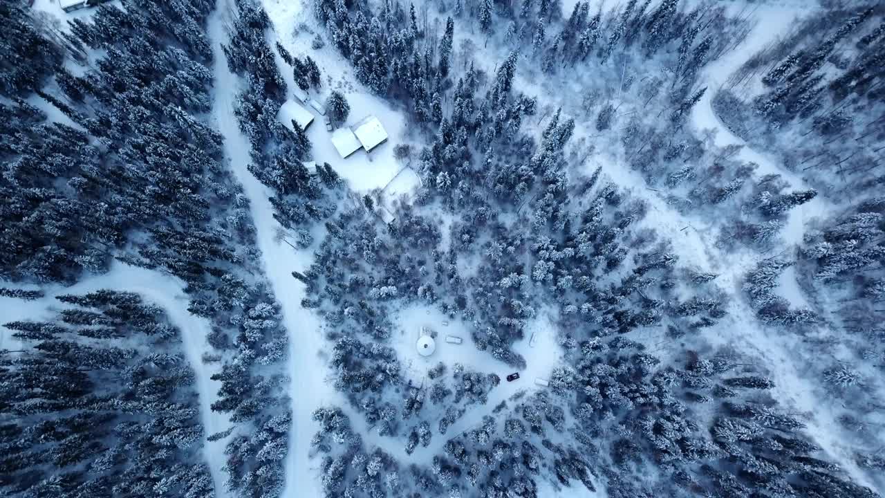 在阿拉斯加德纳里国家公园，宁静的森林中，白雪覆盖的冷杉林中的小木屋的空中以色利前进党拍摄视频下载