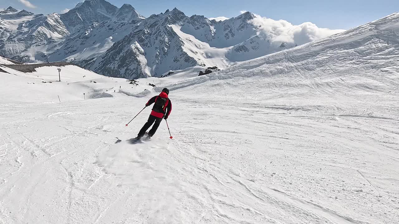 冬天在阳光充足的高山斜坡上滑雪视频素材