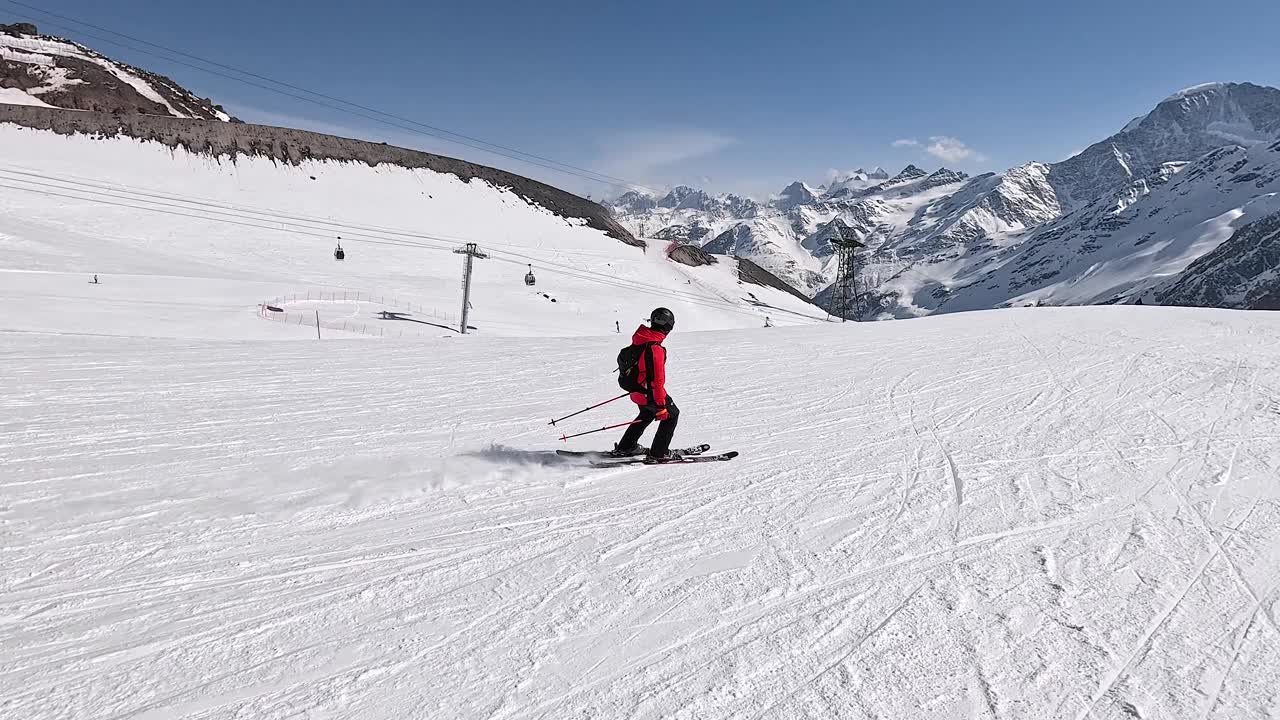 快乐的滑雪者在雪山的滑雪坡上举起双臂视频下载